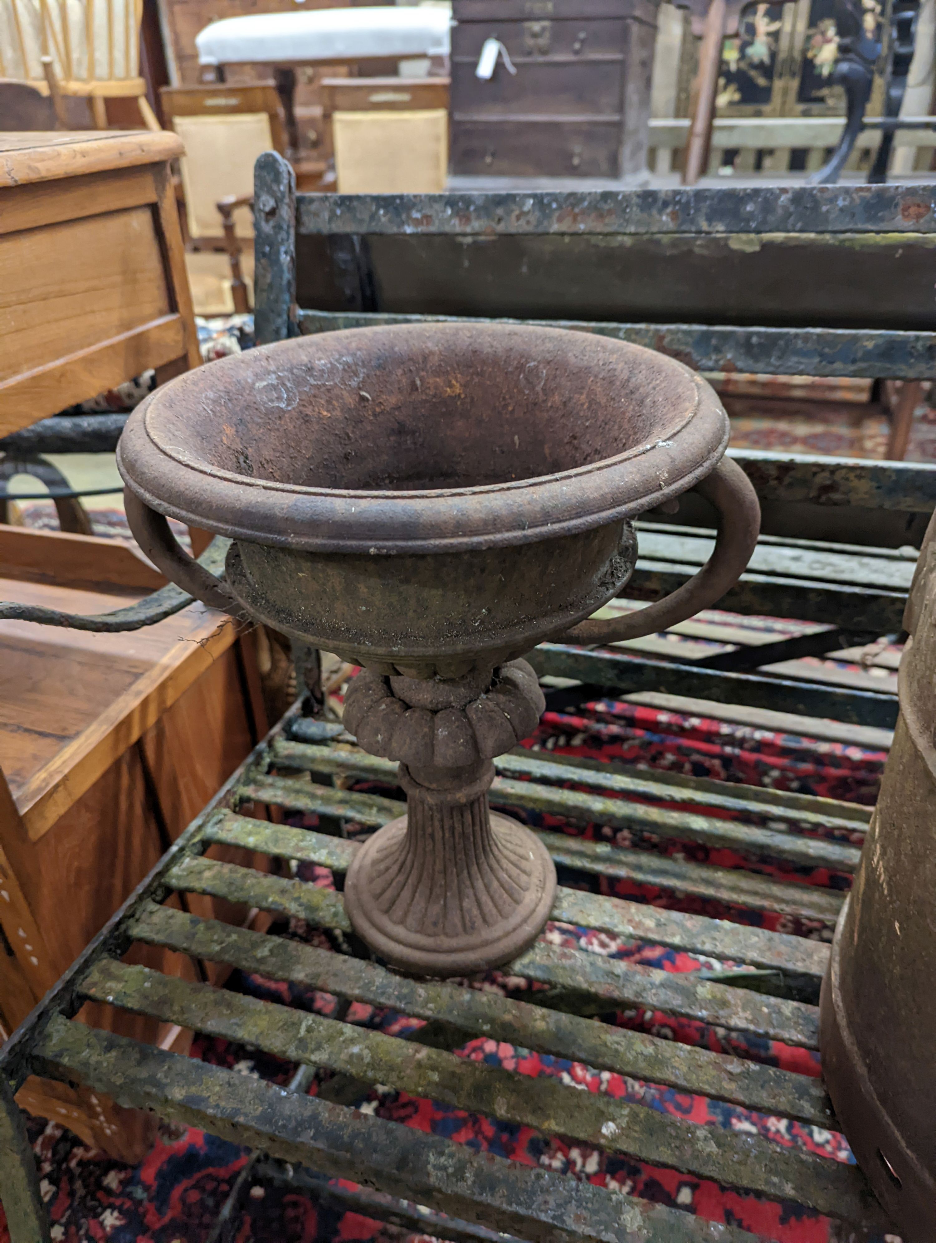 A pair of circular cast iron campana urns, diameter 29cm, height 35cm together with an iron milk churn